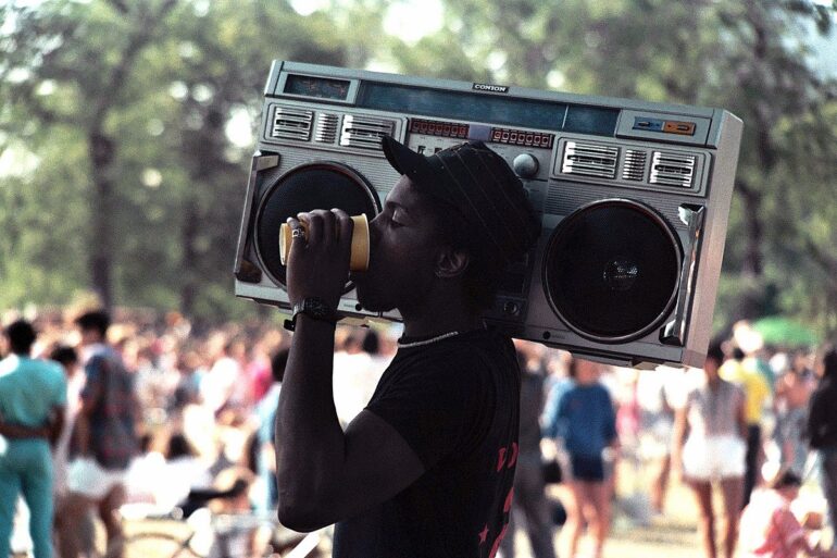 a guy with a giant ghetto blaster on his shoulder