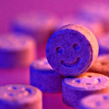 Ensuring Festival Safety: The Fight for On-Site Drug Testing: pink wallpaper of ecstasy tablets.