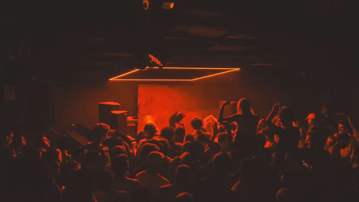 Inside techno club Fuse in Brussels with dancers under red lights in the club